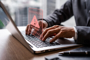 Businessman using computer laptop with caution warning sing for notification error and virus detection spyware, Internet network security concept