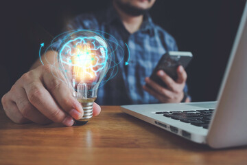 businessman using smart phone signs and Hand of businessman holding illuminated light bulb with network connection line, idea, innovation and inspiration concept. concept creativity idea bulbs.