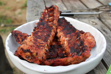 fried pork ribs in a white plate at a picnic