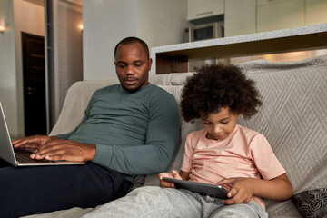 Wall Mural - Father with laptop look at son use digital tablet