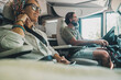 © simona - Side view of happy traveler couple inside camper van rv vehicle driving and enjoying road trip vacation or of grid vanlife lifestyle. People and transport concept. Man and woman travel on motor home