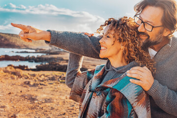 One couple enjoy outdoor leisure activity with happiness. Man hug woman from beck and point finger to show her beautiful landscape. People on vacation and travel destination adventure. Joyful journey