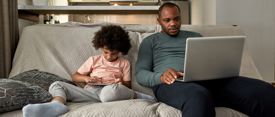 Wall Mural - Boy use digital tablet while father watch laptop