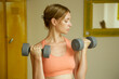 © triocean - Athletic woman doing fitness workout with dumbbells in gym