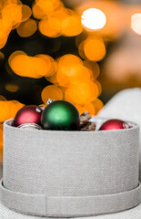 Wall Mural - Round box with Christmas toys against the background of Christmas lights