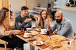 © Andrii - A cheerful group of friends is eating delicious pizza in a restaurant. Friends are sitting in a restaurant and having fun.