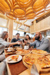 © Andrii - A cheerful group of friends is eating delicious pizza in a restaurant. Friends are sitting in a restaurant and having fun.