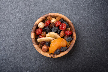 Wall Mural - Wooden bowl with raisins, nuts and other dried fruit, berries as ingredient for tasty dessert