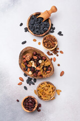 Wall Mural - Wooden bowls with raisins, nuts and dried cranberries as ingredient for tasty dessert