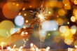 © Pixel-Shot - Woman with Christmas sparkler at night, closeup