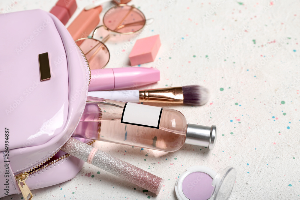 Cosmetic bag with makeup products and accessories on grunge background