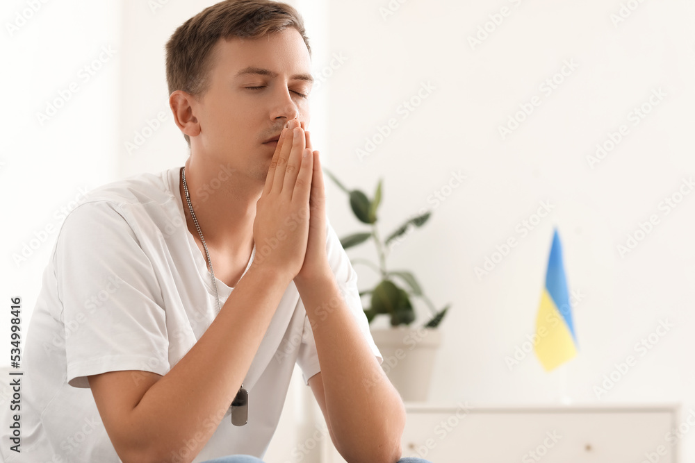 Handsome young man praying at home