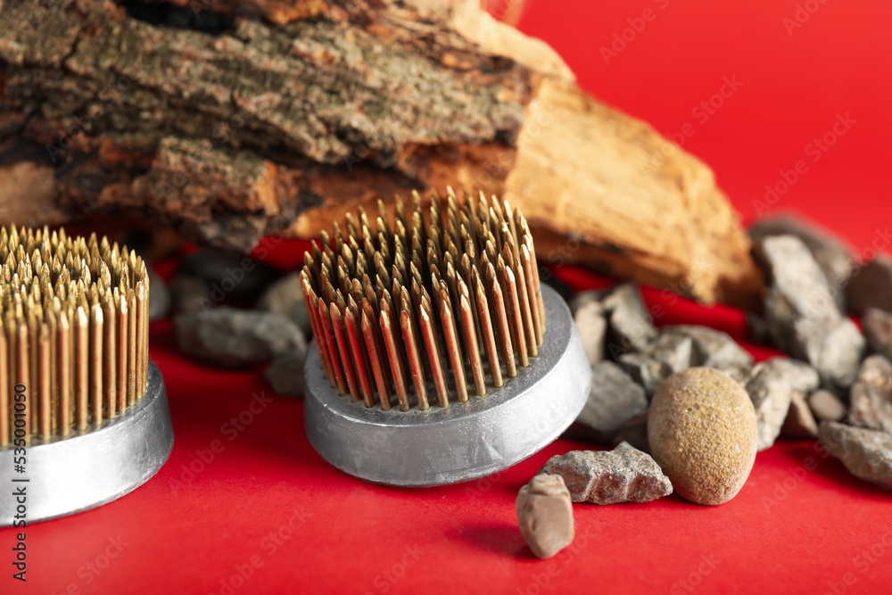 Kenzans for ikebana with rocks and tree bark on red background, closeup
