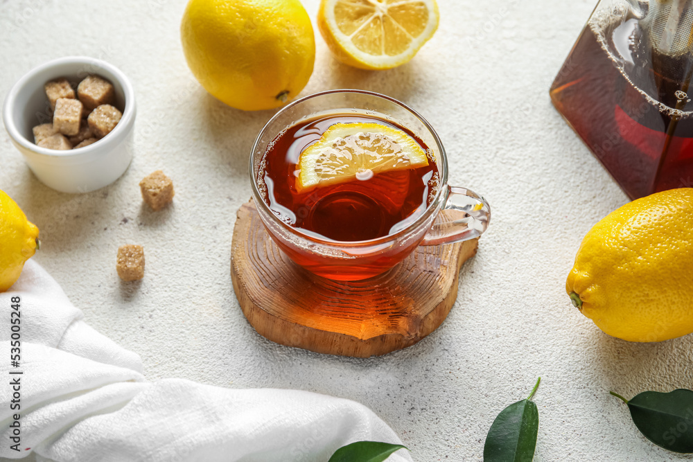 Glass cup of black tea with lemon on white background, closeup