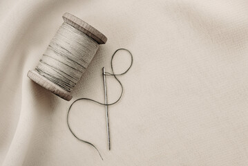 Wall Mural - etro needle and thread lie on the fabric. Tools for a tailor or seamstress. Black and white photography