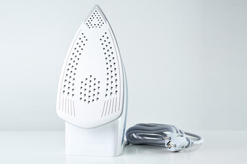 New iron with electrical cable on white background, Modern household appliances to help with daily routine and chores