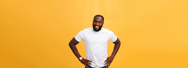 Wall Mural - Portrait of a modern young black man smiling standing on isolated yellow background