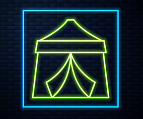 Sticker - Glowing neon line Circus tent icon isolated on brick wall background. Carnival camping tent. Amusement park. Vector