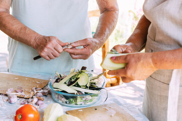 Wall Mural - Two elderly women peel vegetables for cooking vegetable dish preservation. Organic food