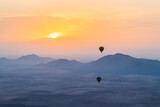 Fototapeta Londyn - hot air balloon flying over the Moroccan desert and the atlas mountains at sunrise