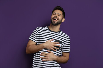 Poster - Young man laughing on purple background. Funny joke