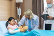 © ronnachaipark - Pediatrician is closely caring and asking about sick girls symptoms, health concepts and child care.