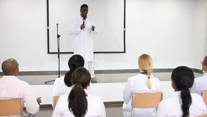 Wall Mural - Confident african american doctor attending lectures within refresher course. Professional development concept. High quality FullHD footage