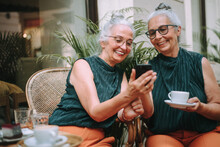 Happy Senior Women Twins Having Coffee Break In City, Smiling And Talking.