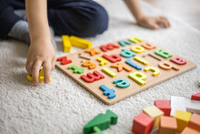 Male Kid Playing With Wooden Eco Friendly Alphabet Letters Board On Table Top View Intellectual Game