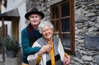 Happy senior couple posing near old countryside house.