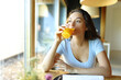© PheelingsMedia - Woman drinking orange juice from glass in a restaurant