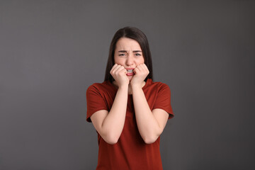 Wall Mural - Portrait of emotional young woman on dark grey background. Personality concept