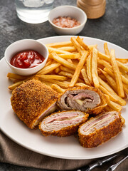 Wall Mural - Crispy Cordon Blue, Chicken fillet roll with ham and cheese. Served in white plate on grey background