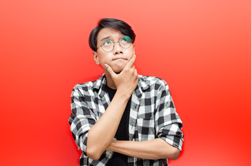 thoughtful asian man thinking and wondering with hand touching skin as thinking gesture isolated ove