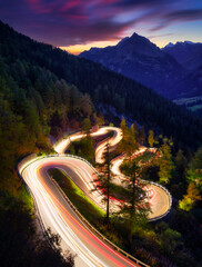 Canvas Print - The mountain pass of Maloja, Switzerland. A road with many curves among the forest. A blur of car lights. Landscape in evening time. Large resolution photo for travel