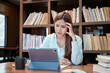 © Katcha - Female student is feeling stressed and headaches while reading data on tablet and thinking about research
