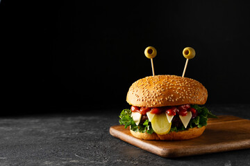 Funny party halloween monster burger on black background, halloween festive