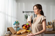 © Kawee - Asian young beautiful woman drinking glass of milk in kitchen at home.