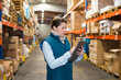 © auremar - woman holding clipboard in warehouse