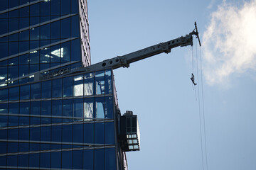 Canvas Print - Crane on top of a skyscraper from Manhattan used to create the system that cleans the glass windows. Skyscraper modern buildings maintenance industry.