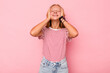 © Asier - Caucasian teen girl isolated on pink background laughs joyfully keeping hands on head. Happiness concept.