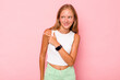 © Asier - Caucasian teen girl isolated on pink background looks aside smiling, cheerful and pleasant.