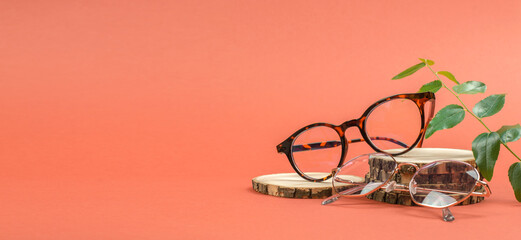 Sticker - Stylish round eyeglasses on a wooden podium. Glasses sale banner