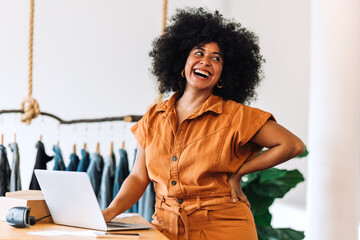 Wall Mural - Female small business owner smiling happily in her online clothing store