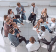 © ASDF - business training participants sitting in a circle and looking at the camera