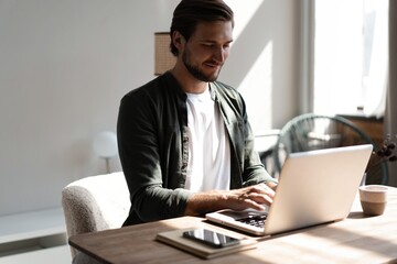 Wall Mural - Male remote working from home and having work confrence video call. Freelancer working on laptop at home office.