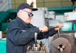 © Светлана Лазаренко - Turning production An elderly man works at a lathe. Turning works.