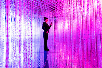 businesswoman holding smart phone in the beautiful bokeh light