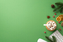 New Year Concept. Top View Photo Of Keyboard Spruce Branches Pine Cones Mug Of Cocoa With Marshmallow Mistletoe Berries And Dried Orange Slices On Isolated Green Background With Copyspace