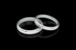 Jewelry wedding band white gold rings on glossy black background. 3D rendering